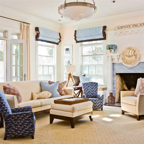 Blue and brown roman shades with cream draperies in a beach themed living room.