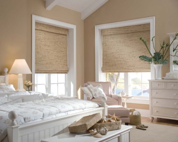Woven wood shades in two corner windows to compliment the beach style bedroom.