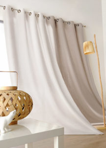 Long flowing drapes that sweep the wood floor, shown in off-white and tan