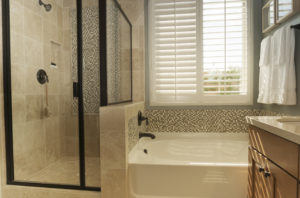 Stylish white interior shutters over an oversized bathtub in a luxury bathroom