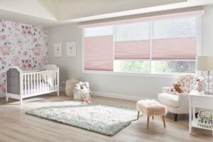 Spacious nursery with a crib in one corner and a changing table on the other side, windows with cordless, light-filtering tandem shades